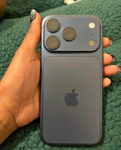 Cliente sosteniendo su iPhone 17 PRO azul, mostrando la parte trasera y el sistema de triple cámara.