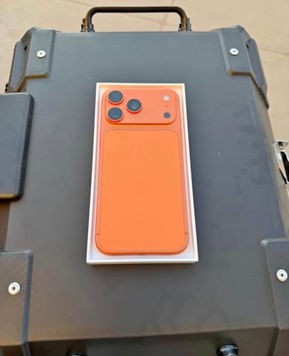 Reseñador muestra la parte trasera de su IPHONE 17 PRO MAX de color naranja dentro de la caja.