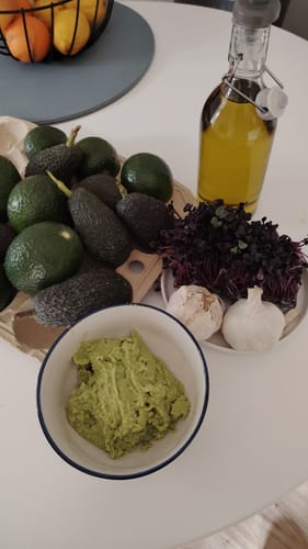 Ein Kunde zeigt die ganzen Avocados und einen cremigen Brotaufstrich, den er daraus zubereitet hat.