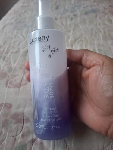 Una clienta sostiene la botella del Spray Bifásico 10 en 1, mostrando el líquido de dos fases.