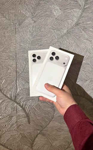 Cliente sosteniendo dos cajas blancas del IPHONE 17 PRO MAX.