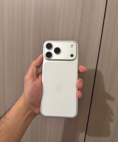 Cliente sosteniendo la parte trasera de un IPHONE 17 PRO MAX blanco.