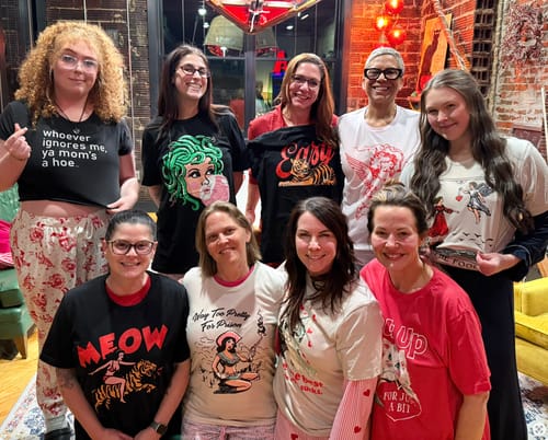 Customer wearing The Fool Tarot Card Tee while posing with a group of friends in various graphic shirts.