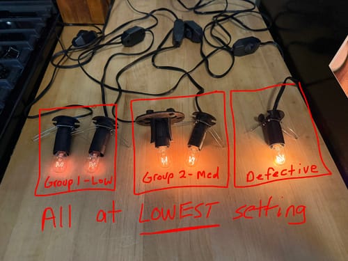 Customer photo comparing five replacement dimmer cords at their lowest setting, showing three different brightness levels.