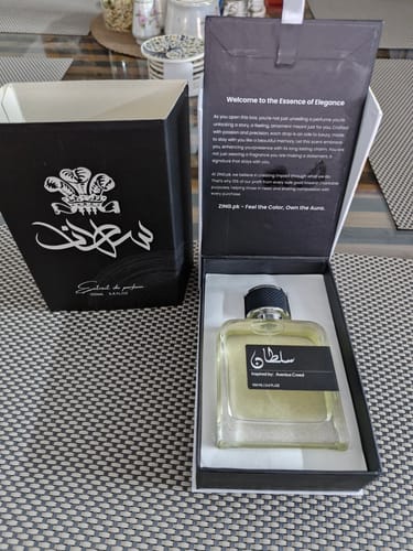 Customer displays a perfume bottle from the OUD Supreme BUNDLE inside its elegant, black presentation box.