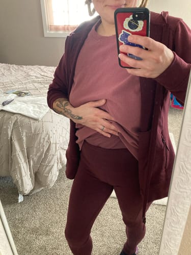 Reviewer shows the high-waisted fit of the Piper Pocket Leggings in Toasted Garnet.