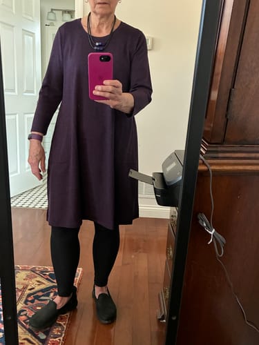 Reviewer standing in a mirror wearing the deep plum Rissa A Line Dress layered over black leggings and shoes.