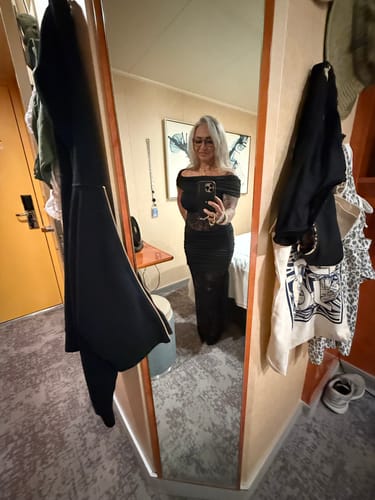Customer taking a mirror selfie while wearing the black Valenne Off Shoulder Lace Maxi Dress in a room.
