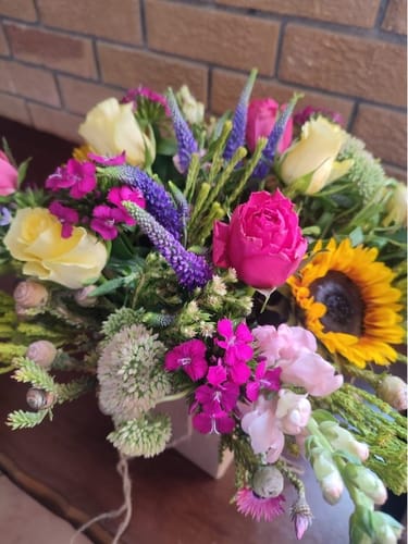 Customer's vibrant Sunflower Posy with a sunflower, yellow roses, and pink and purple blooms.