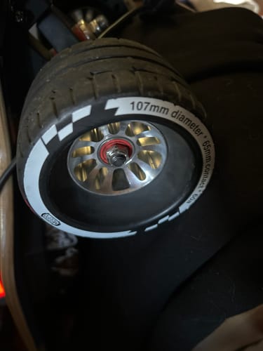 Customer's close-up of a Cyclone 107s rubber wheel with a silver rim, mounted on an electric skateboard.