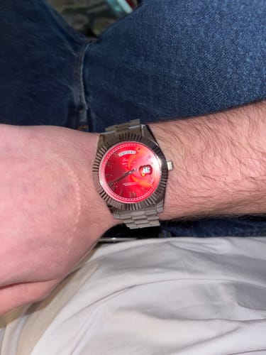 Customer wearing the Lucky Fours® Santos watch, showing its red dial and silver-colored band on their wrist.