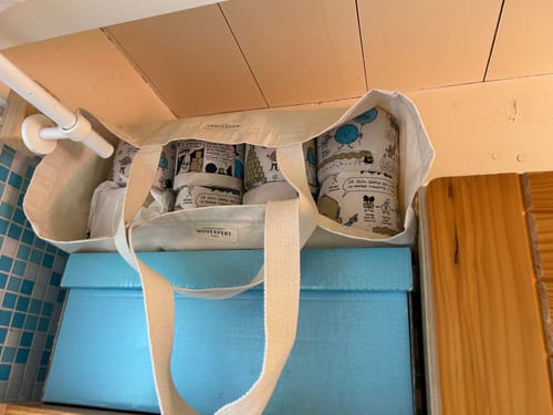 Avis d'un client : plusieurs rouleaux de papier toilette Popee avec leur emballage illustré, rangés dans un sac en toile.