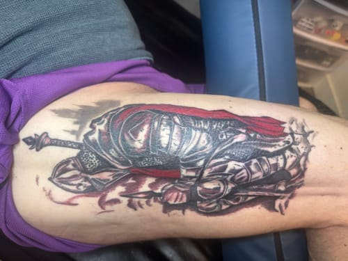 Customer's large, detailed knight tattoo on their leg after a session using Painless Tattoo cream.