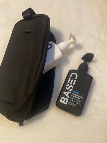 Customer's black Toiletry Bag shown with other products from a bundle on a white surface.