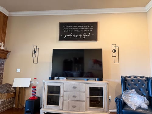 Customer's Goodness Of God Faith Sign II hanging in a living room above a television and media console.