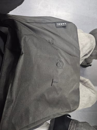 Close-up from a customer of their black ALVA bag, showing the textured fabric and stitched logo detail.