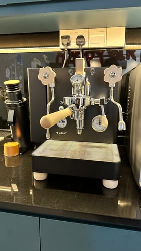 Customer's black Lelit Bianca espresso machine with wood accents, set up on a dark kitchen counter.
