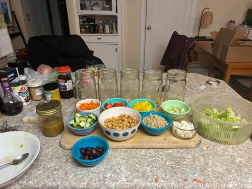 Customer's fresh salad ingredients prepped in bowls next to empty mason jars before using Chalkboard Top Lids.