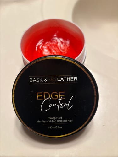 A customer's open jar of Bask & Lather Edge Control showing the red gel product, with the lid propped against it.