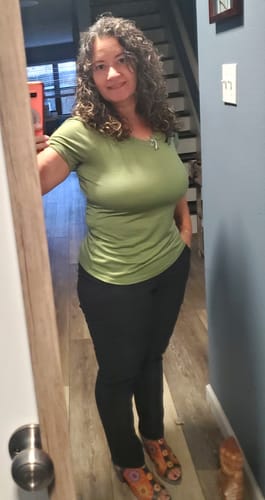 Reviewer taking a mirror selfie wearing the black Nicole Ankle Pants to show their tapered fit.