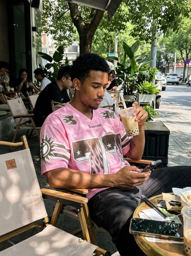 Reviewer wearing the Pink Flame Print Jersey T-shirt while sitting at an outdoor cafe.