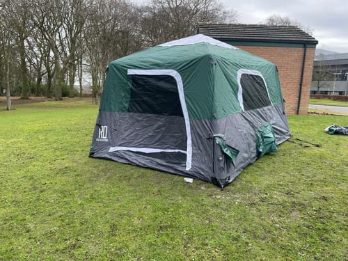 Customer's green and grey Extra Large-Sized Cabin Tent fully assembled on a grassy field.