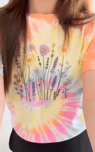 Reviewer wearing the Vintage colour splash t-shirt, showing the floral graphic on a colorful tie-dye background.