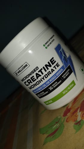 Customer's white tub of Wellcore Micronised Creatine Monohydrate in the Kiwi Kick flavor, shown at an angle.