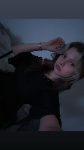 Vista parcial de una clienta usando la prenda negra 'The Temptress Shell' como un top.