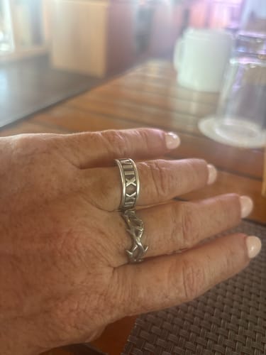 Reviewer's hand resting on a table, showing the detailed Crown Of Thorns Ring on their finger.
