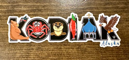 Customer's colorful sticker spelling 'KODIAK' with Alaskan-themed illustrations, shown on a wood surface.