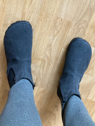 Asiakkaan jalassa rouheat, mustat Vaistoa Kajo -paljasjalkanilkkurit ylhäältä kuvattuna.