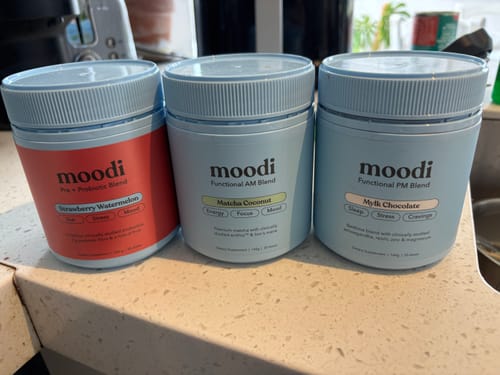 Customer's Luxe AM-PM Bundle products, Matcha Coconut and Mylk Chocolate, shown with another product on a kitchen counter.