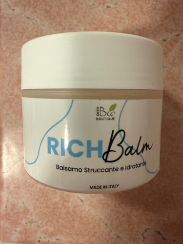 Recensore mostra il barattolo bianco del Rich Balm, un balsamo struccante e idratante.