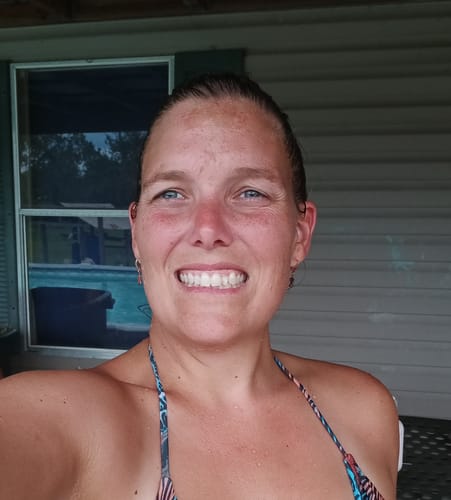 Reviewer smiling, showing her clearer forehead skin after using the Grass Fed Tallow & Honey Balm.