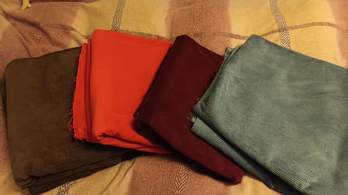 Reviewer's four assorted corduroy fabrics from the bundle, shown in chocolate brown, scarlet, wine, and petrol blue.