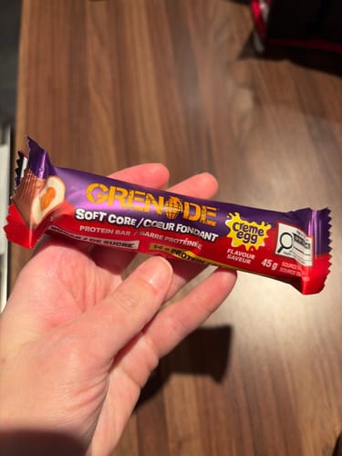 Un client tient la barre protéinée Grenade saveur Creme Egg dans sa main.