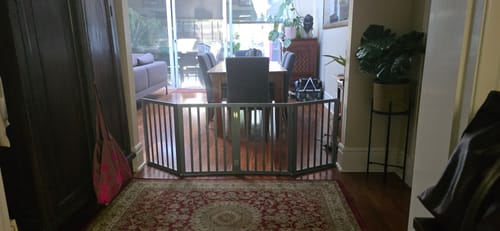 Customer's grey Wooden Pet Gate set up in a zig-zag pattern, blocking a hallway.