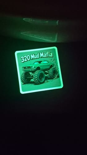 Customer's custom vinyl sticker glowing green in the dark with a '320 Mud Mafia' monster truck design.
