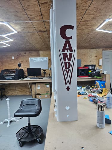 Close-up of the customer's Antique Candy Sign Decal applied vertically to a tall, white candy machine.