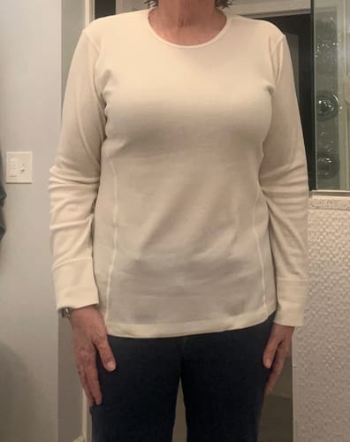 A reviewer wearing the Hannah Long Sleeve Top in buttercream, showing its athletic fit and sleeve length.