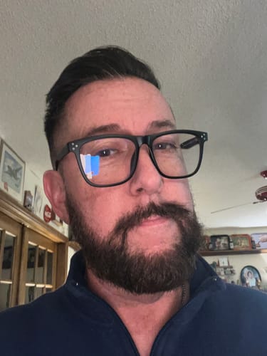 Reviewer wearing the black square-framed JULIEN BLUE LIGHT READERS indoors.
