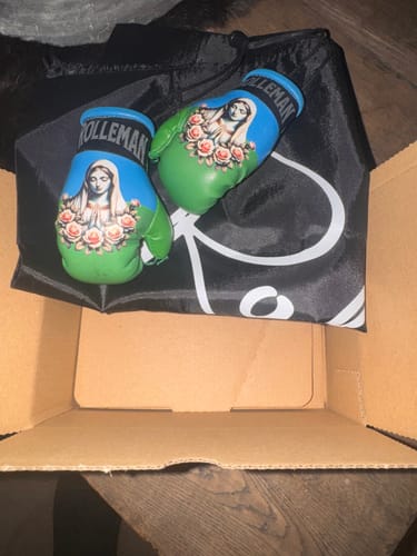 Klant toont de ROLLEMAN 'Engelbewaarder' mini-bokshandschoenen in de verpakking.
