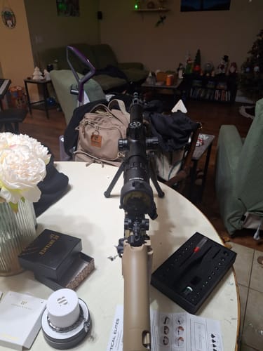 Customer's Site Right 2.0 boresighter kit in its open case on a table, next to a rifle with a scope mounted on it.