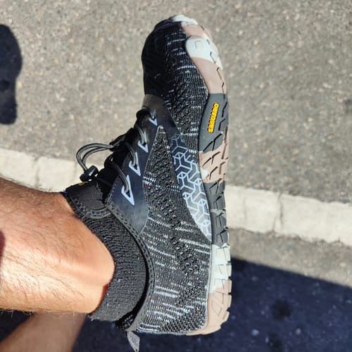 Customer wearing a Smart II barefoot shoe, showing the patterned black upper and sole tread.