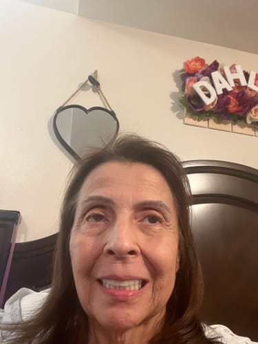 Reviewer smiling, showing her smooth, glowing skin after using the Grass Fed Tallow & Honey Balm.