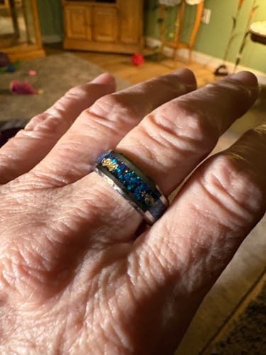 Reviewer's hand wearing the Azaron ring, showing the brilliant blue crystal and gold foil inlay.