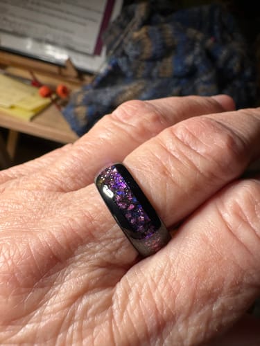 Close-up of a customer wearing the black Solenox ring with its vibrant, sparkling violet inlay.