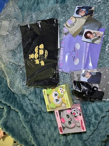 Customer's K-POP RANDOM BOX contents, showing ATEEZ merchandise like plush keychains, a bag, a pouch, and photo cards.