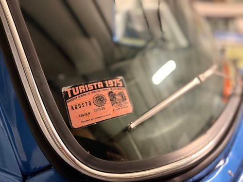 Close-up of a reviewer's custom 'Turista 1975' sample sticker on a vehicle's windshield.